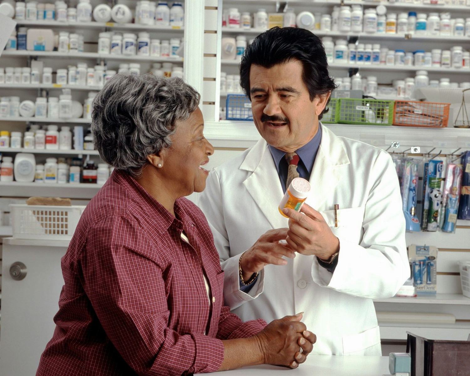 A pharmacist explaining a medicine to a customer